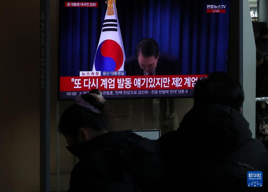 12月7日，在韓國首爾火車站，民眾觀看總統(tǒng)尹錫悅發(fā)表講話的電視畫面。新華社記者 姚琪琳 攝