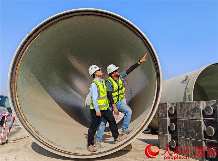 工作人員在察看輸水管情況。人民網(wǎng)記者 管克江攝