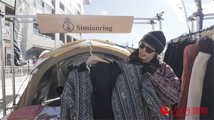 藤田周正在展示自己設(shè)計(jì)的滑雪服。人民網(wǎng)記者 袁蒙攝