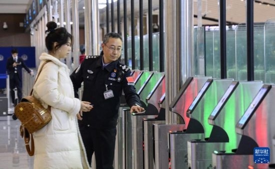 1月2日，大興機(jī)場(chǎng)邊檢站警察指導(dǎo)旅客使用自助出境設(shè)備。新華社記者 李欣 攝