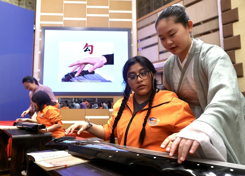 2024年3月20日，美國(guó)華盛頓州中學(xué)生代表團(tuán)北京大學(xué)交流活動(dòng)在北京大學(xué)英杰交流中心舉行。圖為來自華盛頓州的中學(xué)生體驗(yàn)古琴。