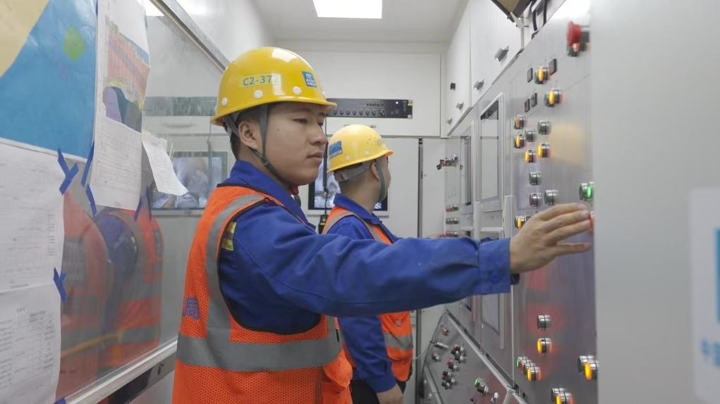 盾構(gòu)司機(jī)何曉波在駕駛室內(nèi)調(diào)試盾構(gòu)機(jī)參數(shù)。（劉芬攝）