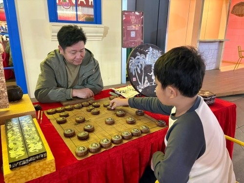 柯秋楓與市民下椰雕象棋。人民網 陳葉欣攝