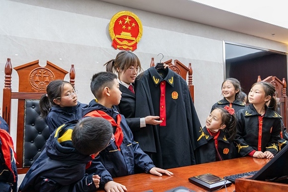 圖②：干警向同學(xué)們介紹法袍。