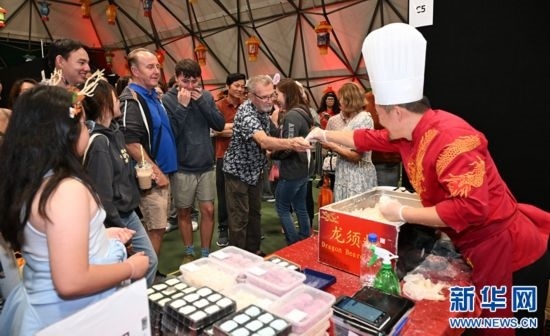 圖為游客在燈節(jié)現場購買小吃。（圖片由奧克蘭中國文化中心提供）