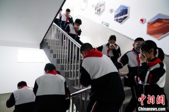  圖為學(xué)生們進(jìn)行應(yīng)急疏散演練。中新社記者 趙宇航 攝