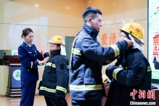 圖為學(xué)生們現(xiàn)場(chǎng)穿戴消防頭盔和戰(zhàn)斗服。中新社記者 趙宇航 攝
