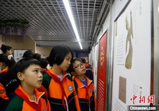 圖為學生參觀青海省博物館“1+3”主題流動展覽，了解木舞俑。中新社記者 馬銘言 攝