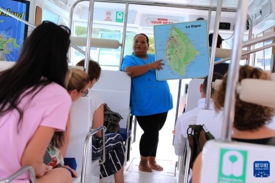 3月15日，一名導(dǎo)游在游艇上為游客介紹塞舌爾拉迪格島。新華社記者 董江輝 攝