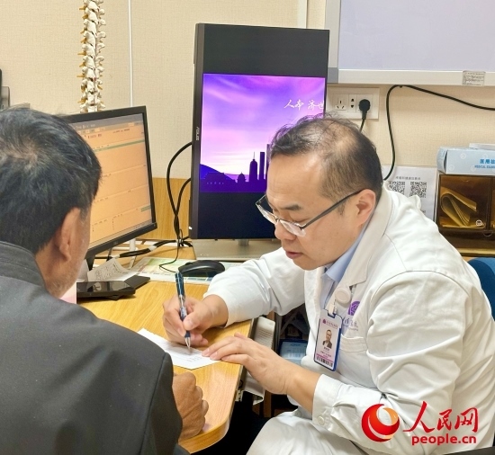 路桂軍接診時為患者寫下用藥提示。人民網(wǎng)記者 金慧慧攝