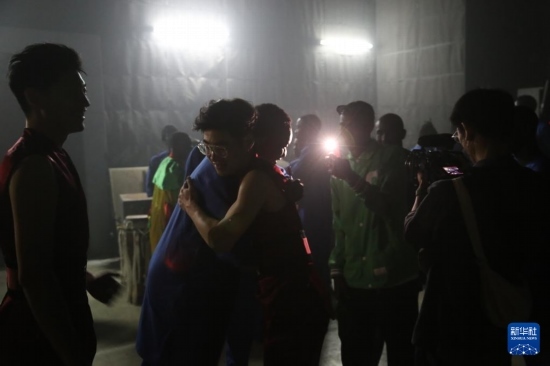 4月10日，在塞內(nèi)加爾首都達喀爾的國家大劇院，中央音樂學院進擊打擊樂團成員與塞內(nèi)加爾杜杜·恩迪亞耶·羅斯打擊樂團成員在演出后臺擁抱。新華社記者 司源 攝