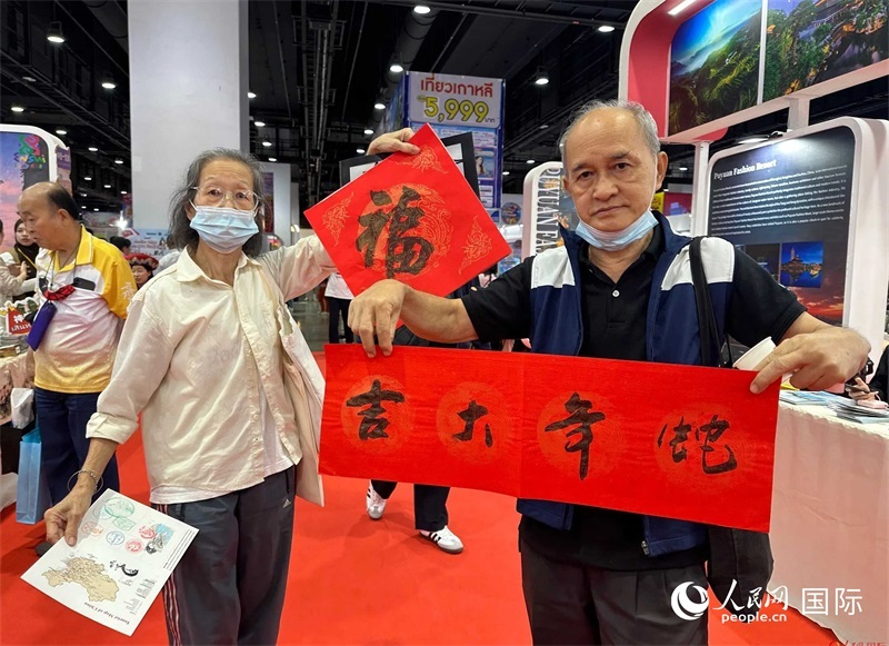 2025蛇年春節(jié)，泰國市民展示他們領(lǐng)到的華人手寫春聯(lián)。人民網(wǎng)記者 簡(jiǎn)承淵攝