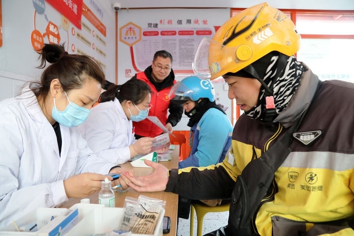 2025年3月5日，志愿者在山東省棗莊市市中區(qū)一工會(huì)驛站為外賣員免費(fèi)測(cè)量血糖。新華社發(fā)（王海楠攝）