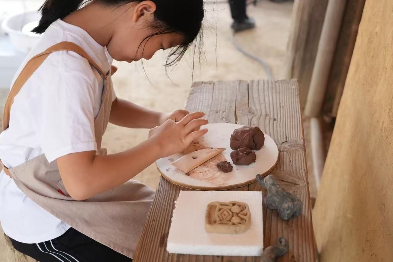 游客制作良渚特色陶藝品。良渚博物院供圖