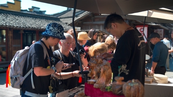 “五一”期間，游客正在烏鎮(zhèn)“水鄉(xiāng)碼頭”挑選購買文創(chuàng)產(chǎn)品。受訪者供圖