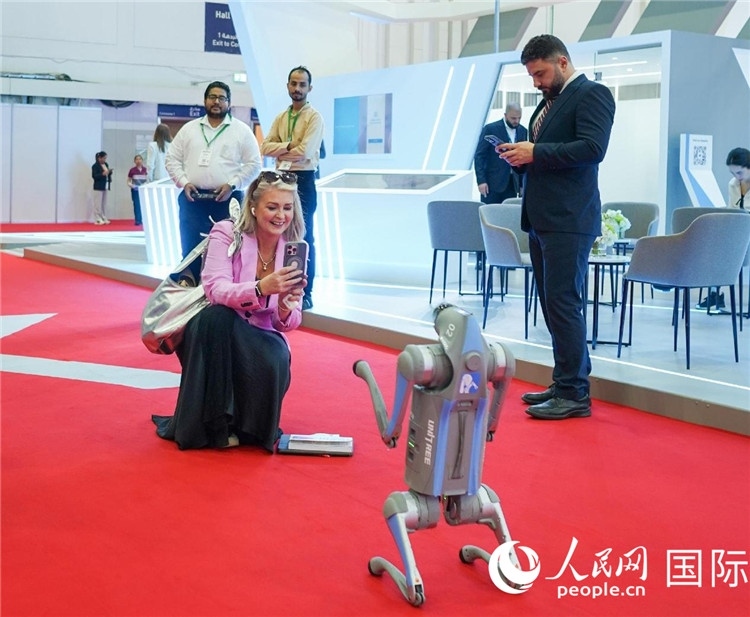 與會(huì)嘉賓被中企機(jī)器人吸引。人民網(wǎng) 塔里克·易卜拉欣攝
