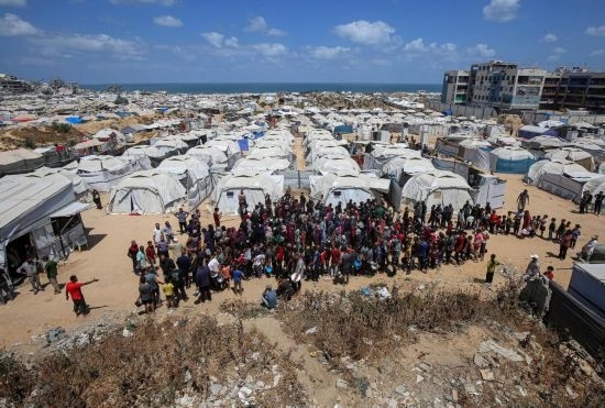 5月28日，人們在加沙城西部的沙提難民營等待領(lǐng)取救助食物。新華社發(fā)（里澤克·阿卜杜勒賈瓦德攝）