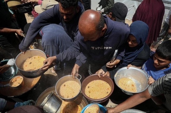 5月28日，人們在加沙城西部的沙提難民營領(lǐng)取救助食物。新華社發(fā)（里澤克·阿卜杜勒賈瓦德攝）