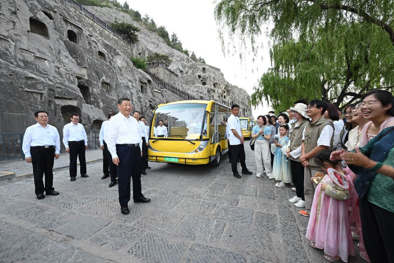 5月19日，習近平在洛陽龍門石窟考察時，同游客親切交流。