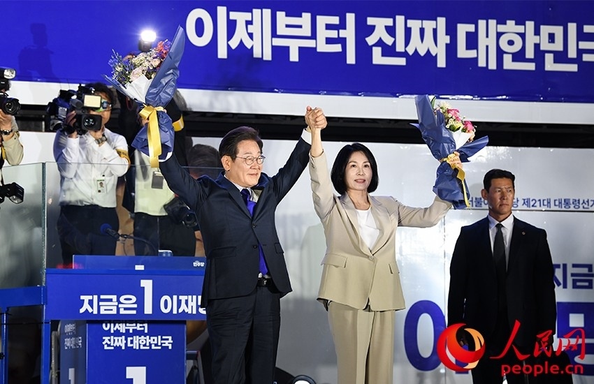 6月4日凌晨，確定當(dāng)選韓國(guó)總統(tǒng)的李在明舉手向歡呼的支持者們致意。 人民網(wǎng) 康炯彬攝